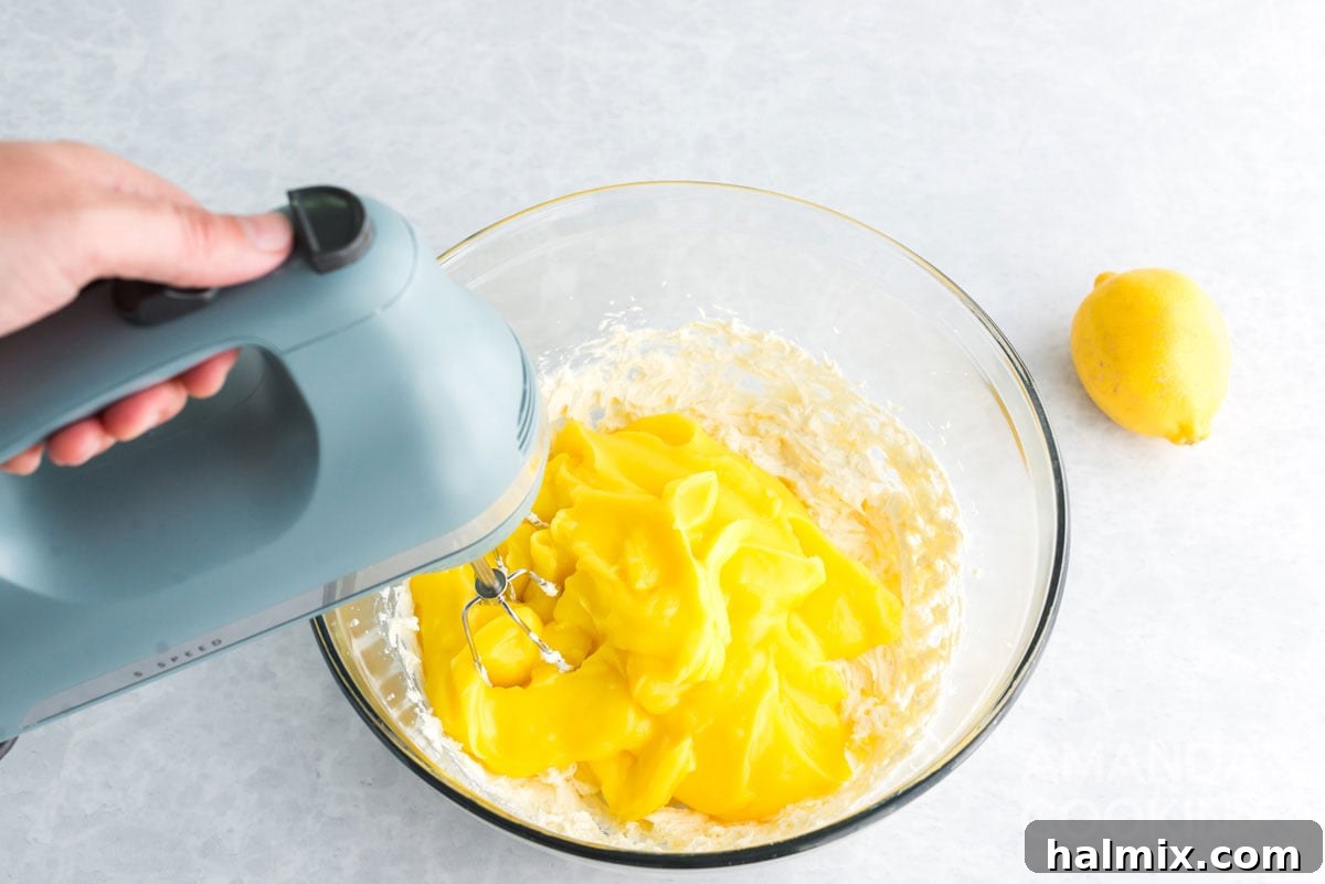 Mixing the prepared lemon pudding with the beaten cream cheese mixture.