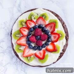 An overhead photo of fruit cut up on top of a brownie pizza, perfectly arranged and ready to be enjoyed.