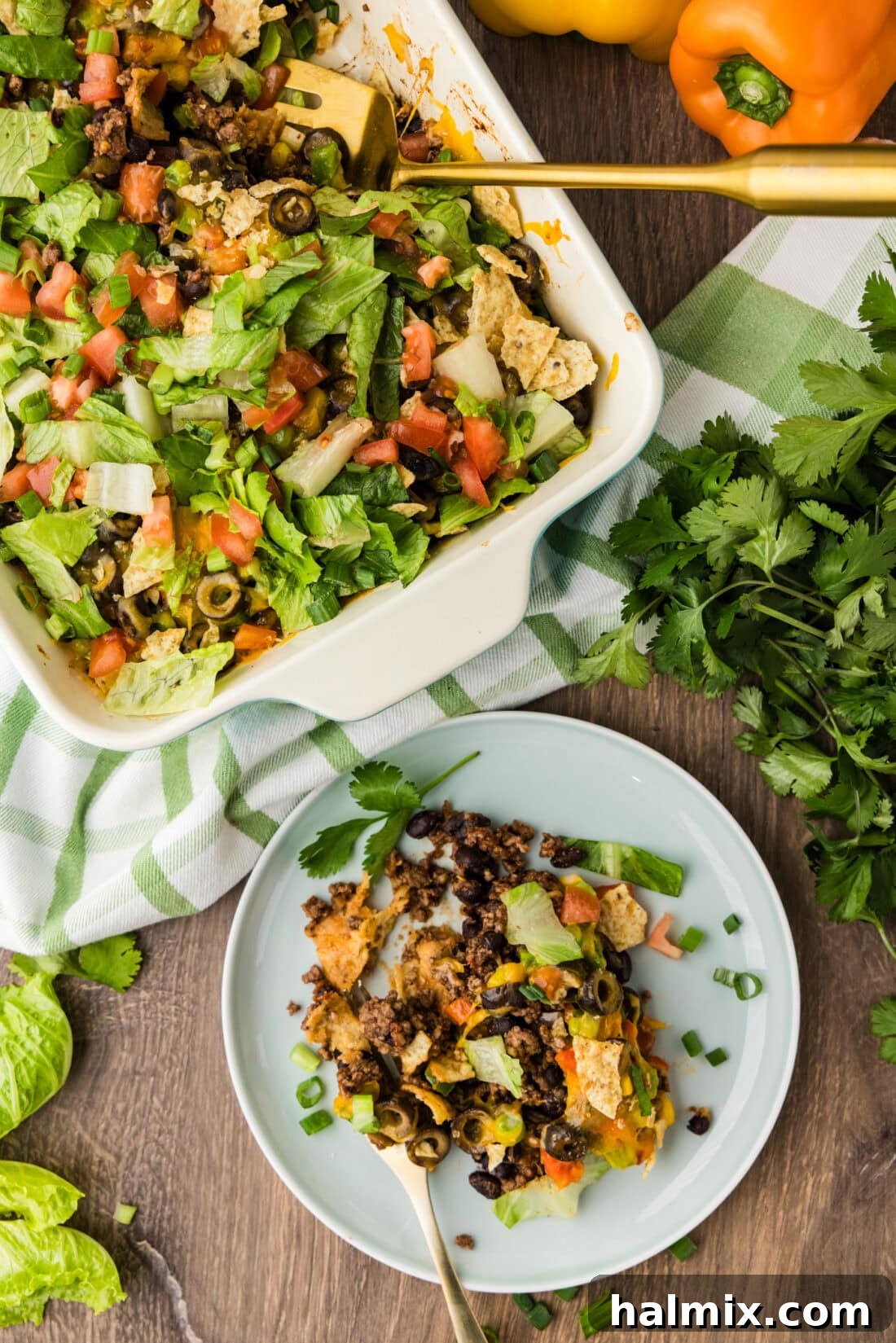 Ultimate Taco Bake 2 Serving of Taco Casserole on a plate with the rest of the casserole behind it