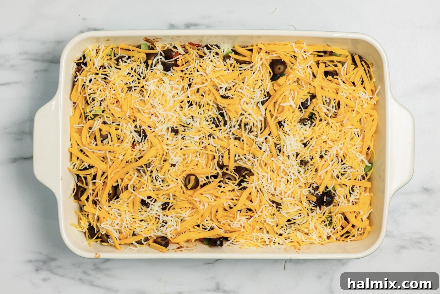Ultimate Taco Bake 9 Shredded cheese on top of taco casserole in a dish