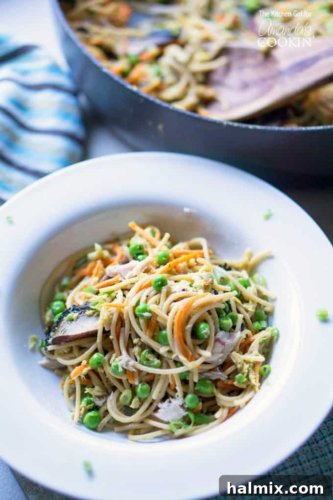Quick and Light Tuna Noodle Skillet 2 A close up of a white bowl filled with light and healthy tuna casserole skillet, garnished with fresh herbs.