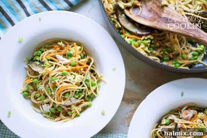 Quick and Light Tuna Noodle Skillet 4 An overhead view of a white bowl filled with light and healthy tuna casserole next to the entire skillet of tuna casserole.