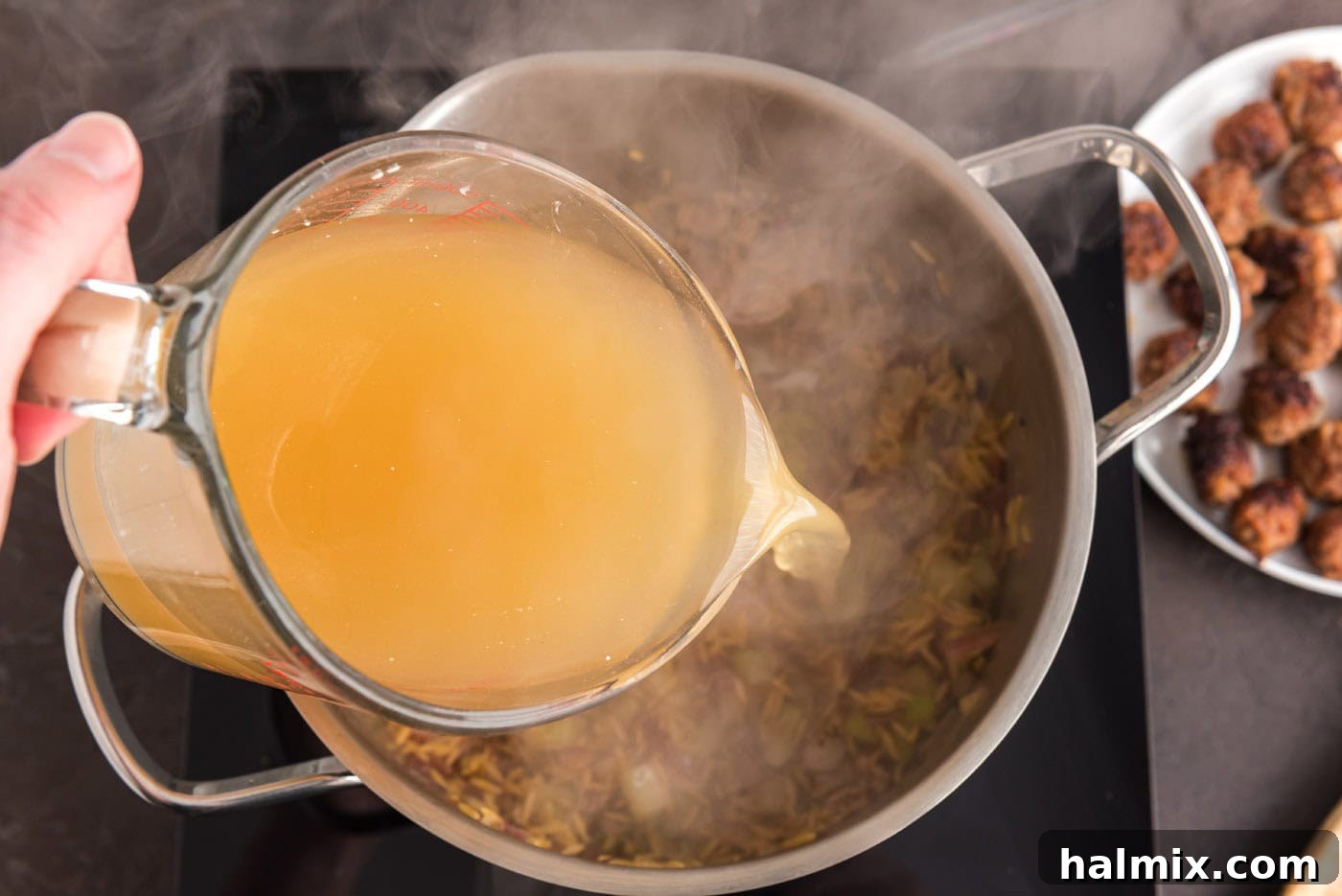 Savory Sausage Orzo Medley 8 pouring chicken broth into stock pot