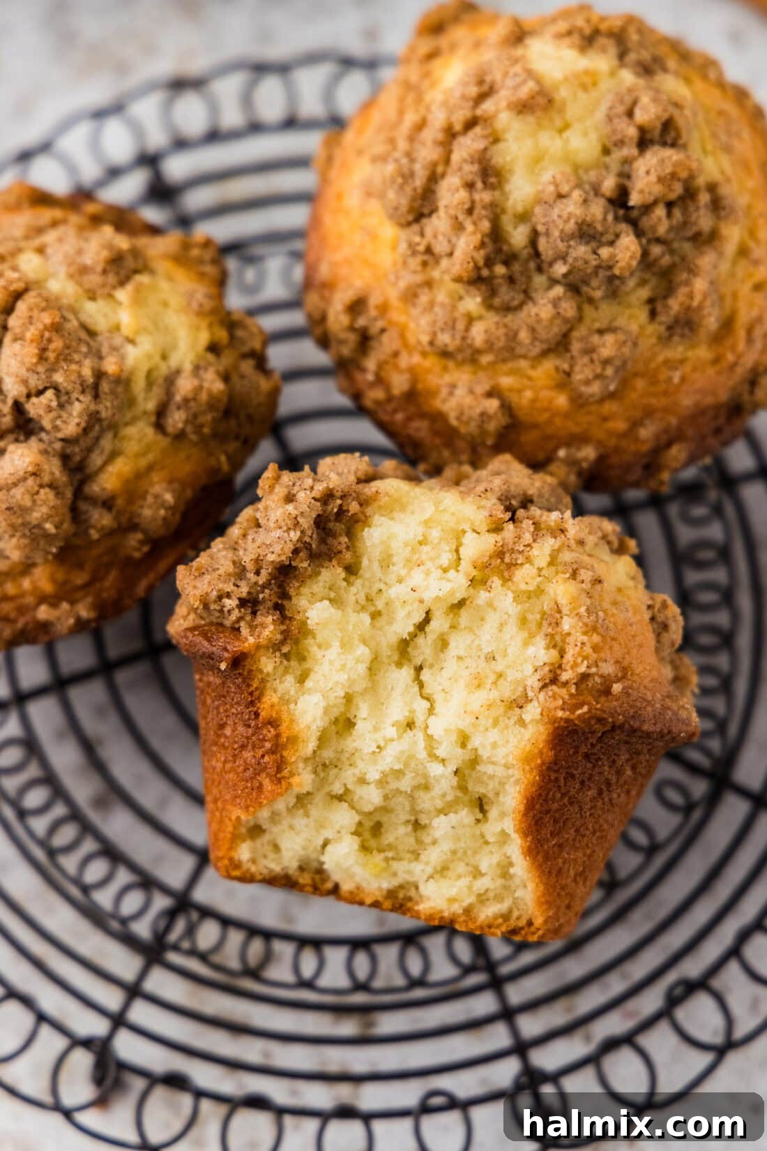 Cinnamon Streusel Muffins on a wire rack with a bite taken out of one