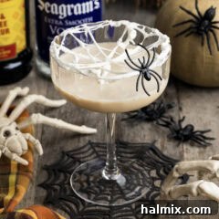 Spiderweb Cocktail with a fake spider on the glass, ready for a Halloween party.