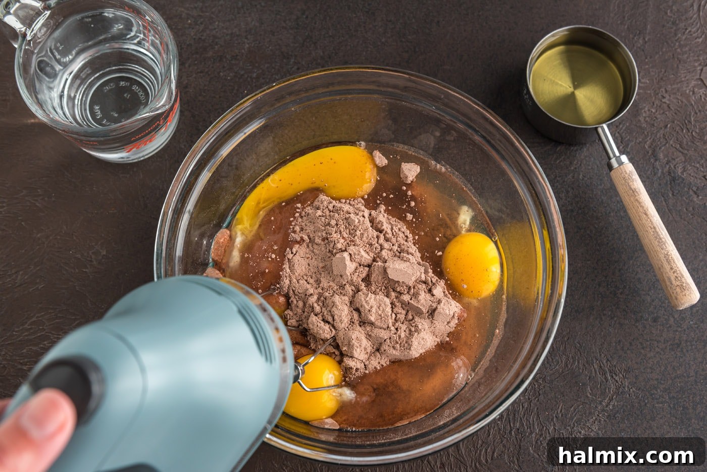 Enchanted Chocolate Pumpkin Cake 5 mixing cake mix with eggs, oil, and water with an electric mixer