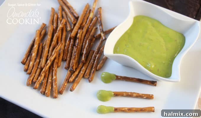 A plate with pretzel sticks, a bowl of boogers (cheese wiz), and boogers on a stick, showcasing a simple yet effective Halloween party spread.