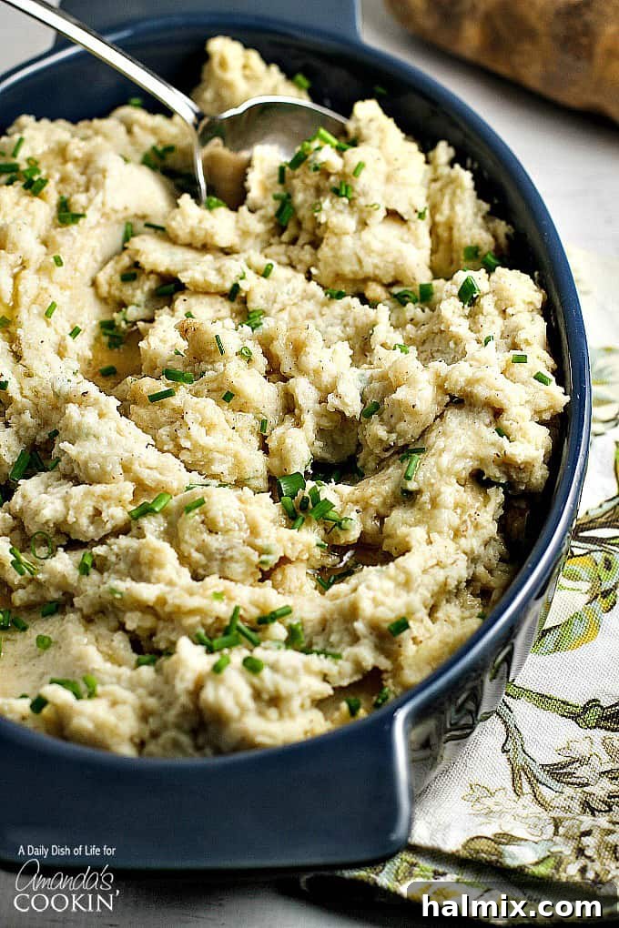 A close up overhead picture of creamy brown butter mashed potatoes, garnished with fresh herbs.