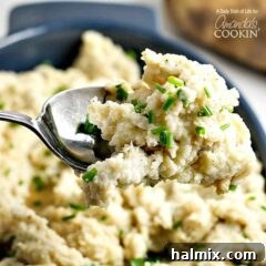 A close up picture of a spoonful of mashed potatoes, showcasing its creamy texture and golden hue.