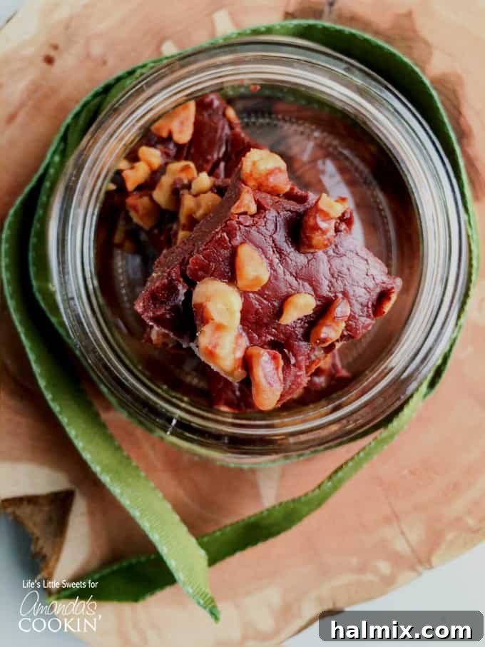 Handful of chocolate walnut fudge squares ready for serving.