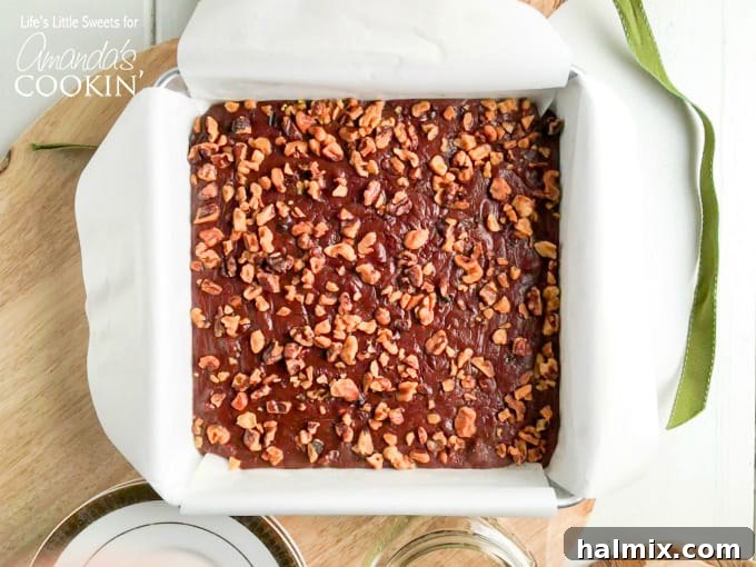 Close-up of three chocolate walnut fudge squares on a plate.