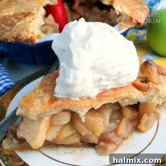 A slice of delicious homemade apple pie with a scoop of ice cream, ready to be enjoyed.