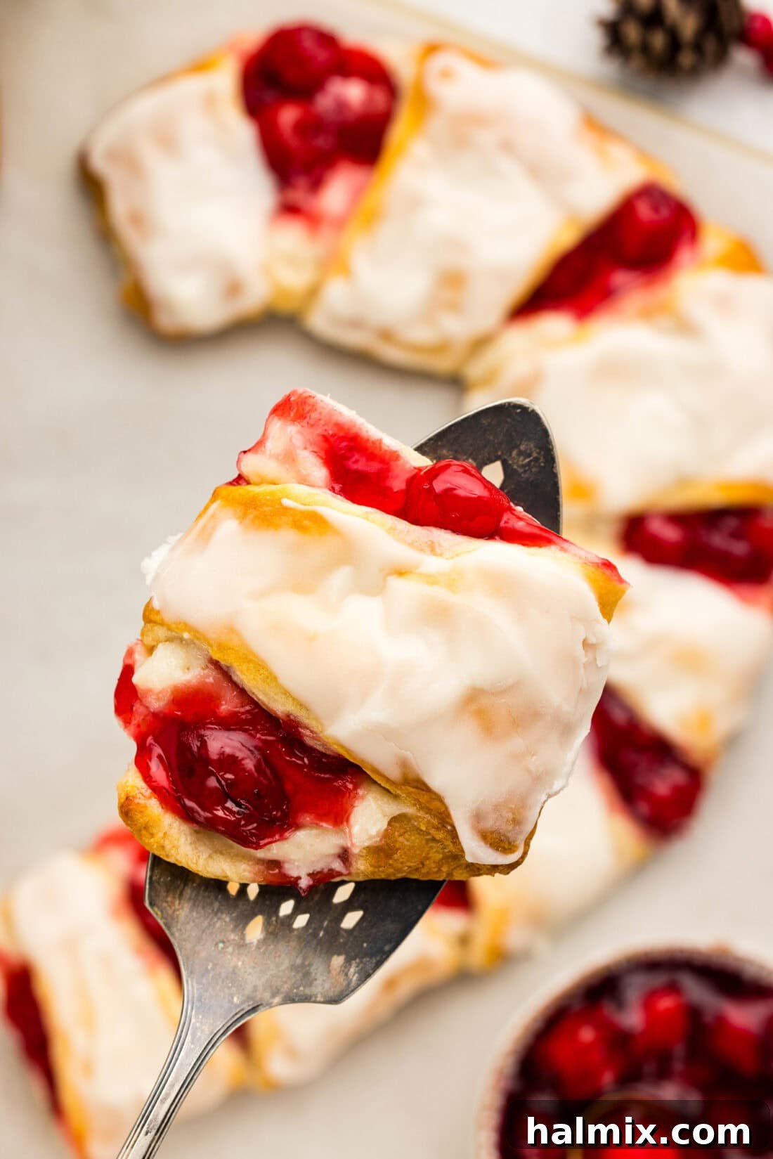 Slice of Candy Cane Danish held above the rest of the Candy Cane Danish