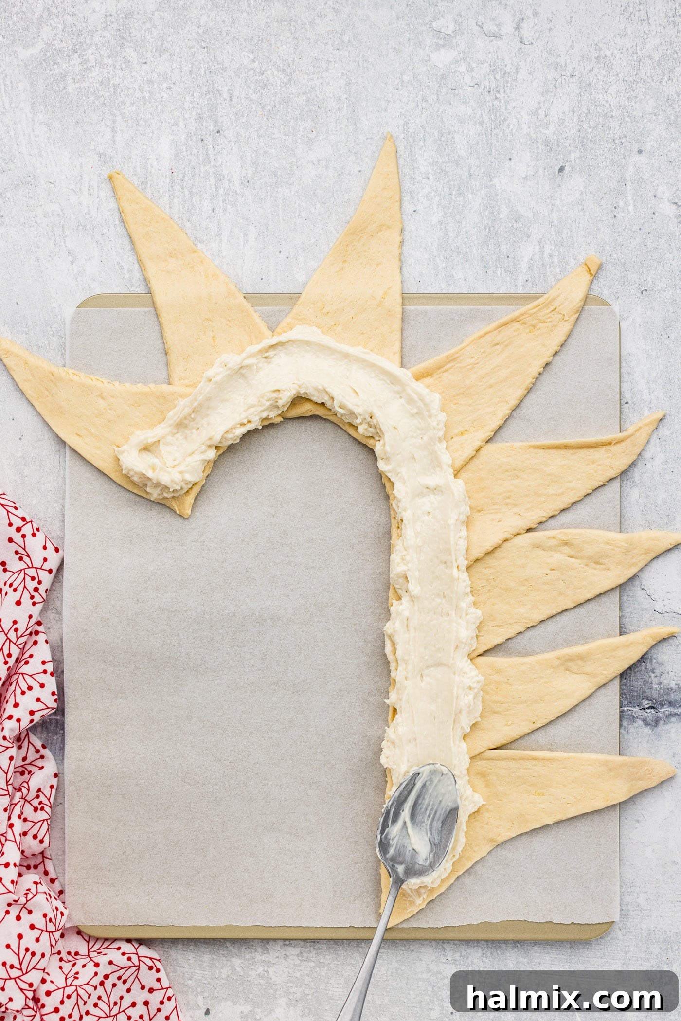 spreading cream cheese filling inside crescent roll dough