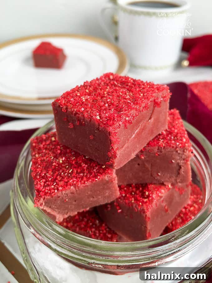 Squares of red velvet fudge with red sprinkles on top.