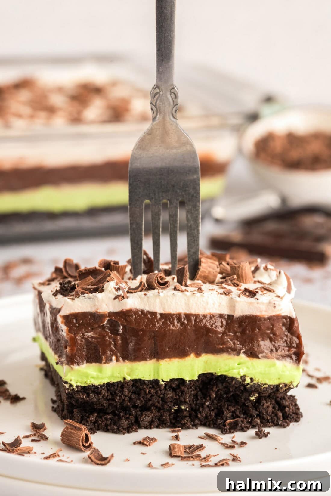 Invigorating Mint Chocolate Lasagna 2 Fork stuck in a slice of Mint Chocolate Lasagna, showcasing its perfect layers