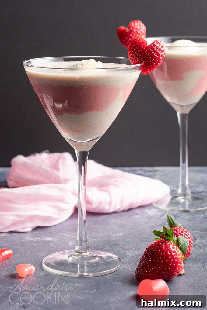 A stunning Pink Mudslide cocktail in a martini glass, garnished with a fresh strawberry for Valentine's Day.
