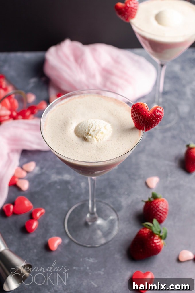 A scoop of rich vanilla ice cream being added to a Pink Mudslide cocktail, showcasing its creamy texture.