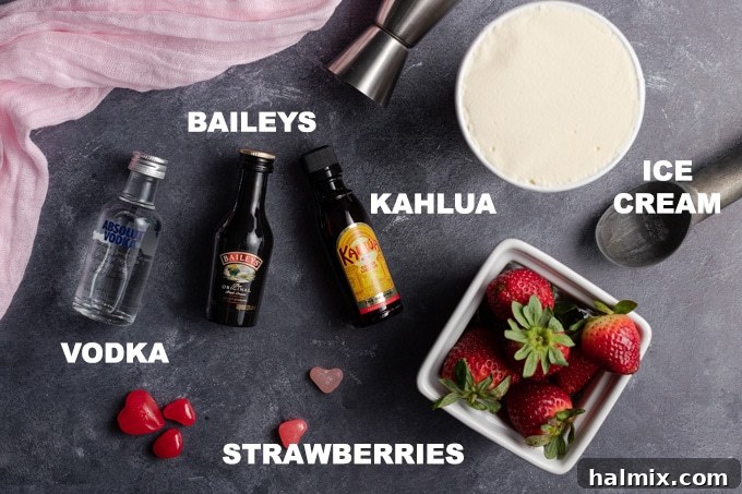 All the fresh ingredients neatly laid out for making a delicious Pink Mudslide, including strawberries, Irish cream, coffee liqueur, vodka, and vanilla ice cream.