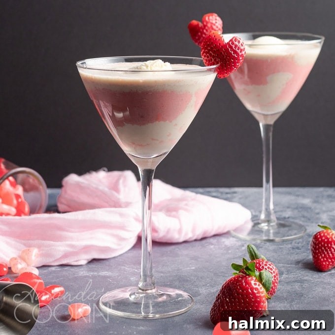 A finished Pink Mudslide cocktail, beautifully garnished with a heart-shaped strawberry, perfect for a romantic celebration.
