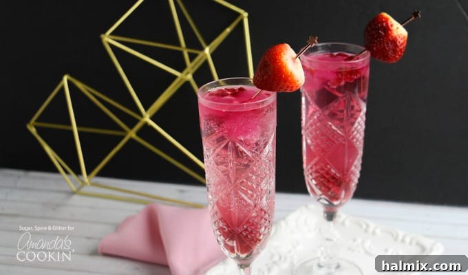 Close-up of a Cupid's Cocktail with a strawberry garnish and sparkling bubbles.
