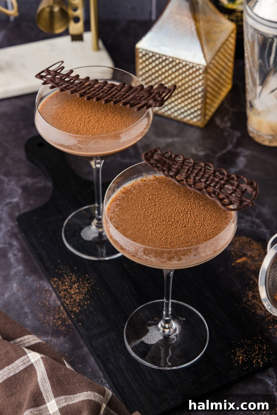 Two Baileys Chocolate Martinis topped with cocoa powder and chilled melted chocolate swirls