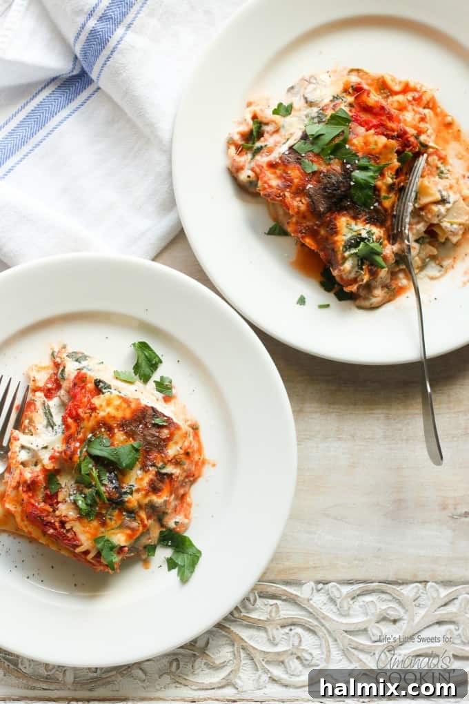 Hearty Garden Lasagna 5 An overhead picture of two white plates with a serving of veggie lasagna on top.