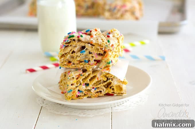 Two funfetti marshmallow cereal bars artfully arranged on a small white plate, ready for serving.