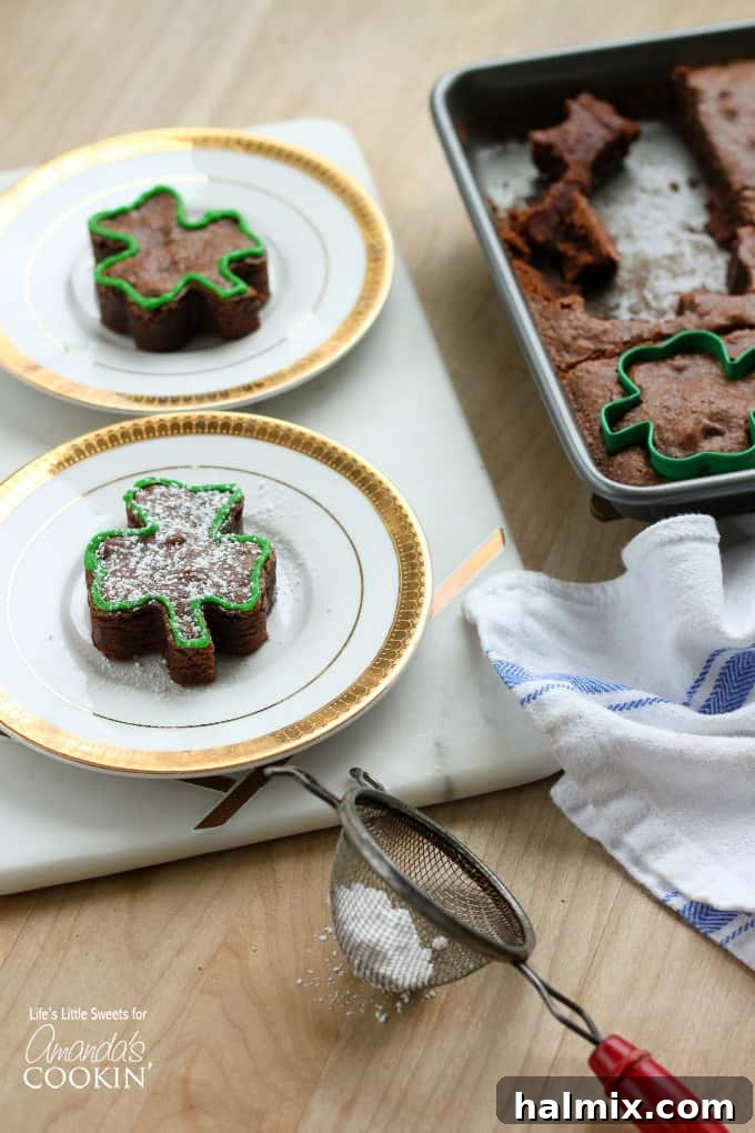 A single, perfectly cut shamrock brownie displayed on a simple white plate, ready for St. Patrick's Day