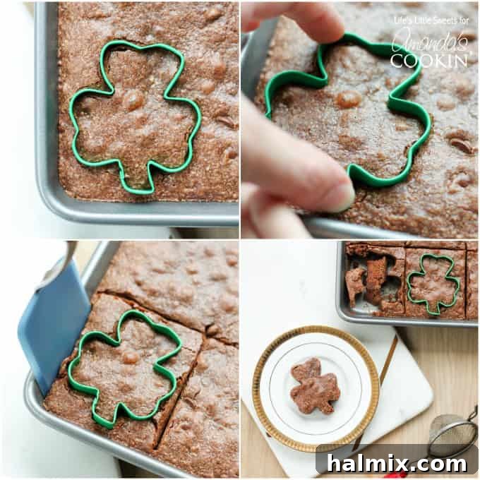 A baker's hand pressing a shamrock cookie cutter into a pan of rich, baked brownies