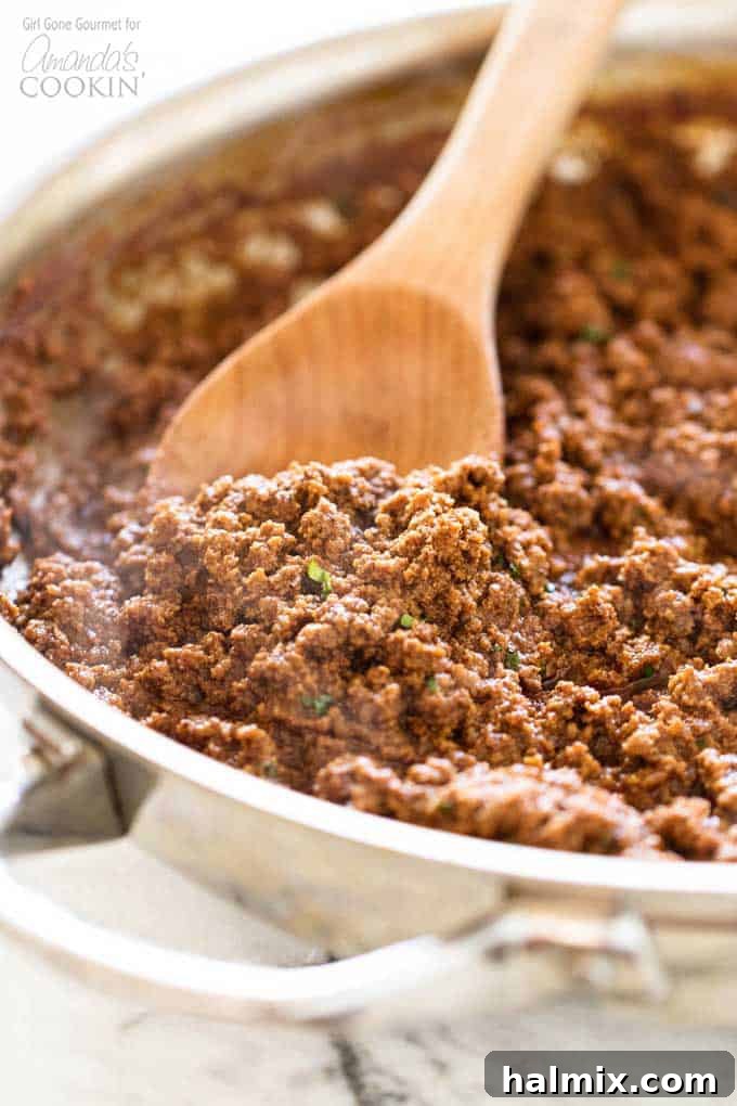 Homemade chili simmering in a pan, ready for oven chili dogs