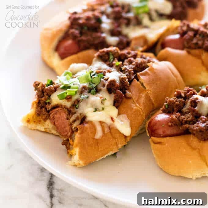 A delicious oven chili dog with a bite taken, showing the chili and melted cheese