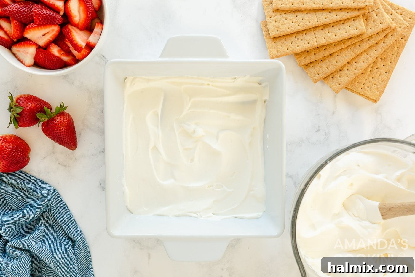 Whipped cream spread evenly in a baking dish, forming the first layer.