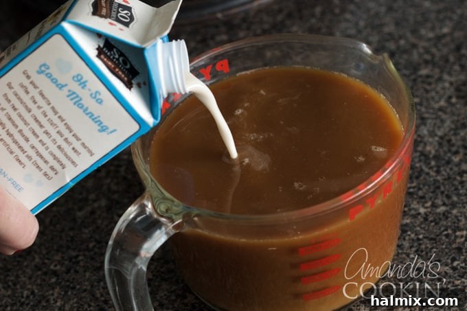 Refreshingly Smooth Cold Brew 8 Pouring rich, white coconut milk creamer into a glass of dark cold brewed coffee, creating a swirling blend of colors.