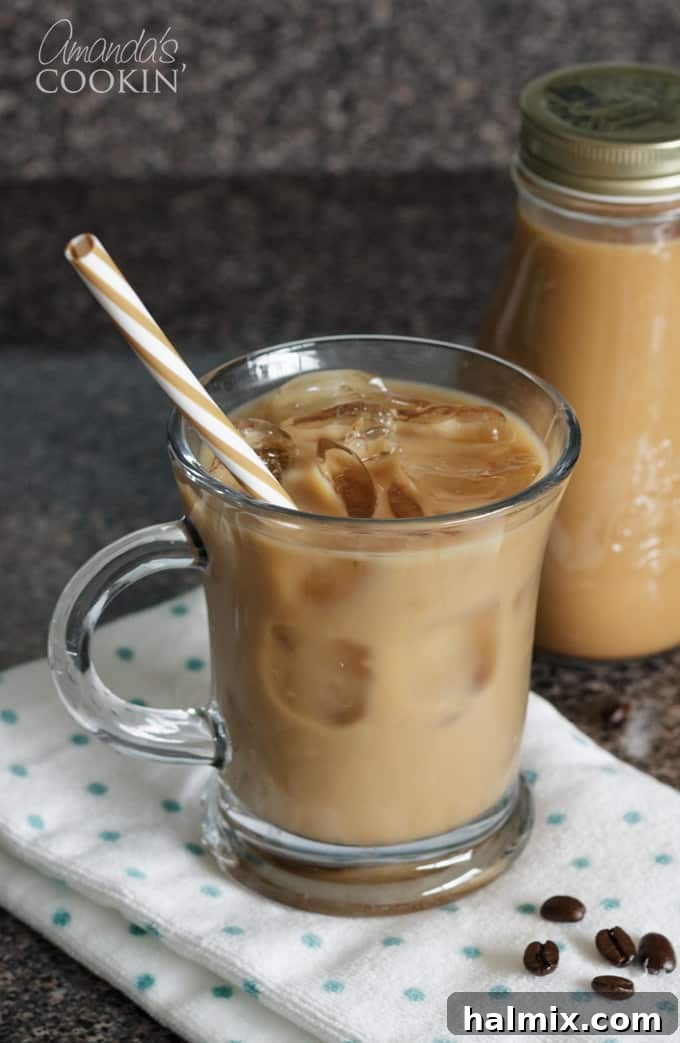 Crafting delicious vanilla iced coffee with cold brew concentrate is surprisingly easy, perfect for those who enjoy a smooth, less acidic coffee. A tall glass mug showcasing homemade cold brewed iced coffee with ice cubes, ready for a refreshing sip.