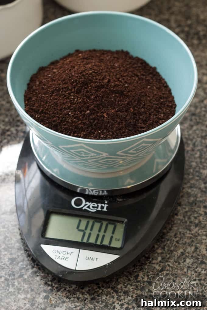 Refreshingly Smooth Cold Brew 3 A hand measuring 4 ounces of ground coffee on a kitchen scale, highlighting the precision needed for the cold brew recipe.