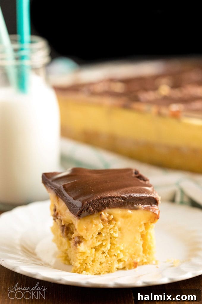 slice of boston cream poke cake on a white plate with bottle of milk in background