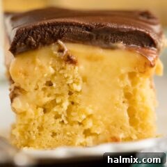close up of a slice of Boston cream poke cake showing pudding inside