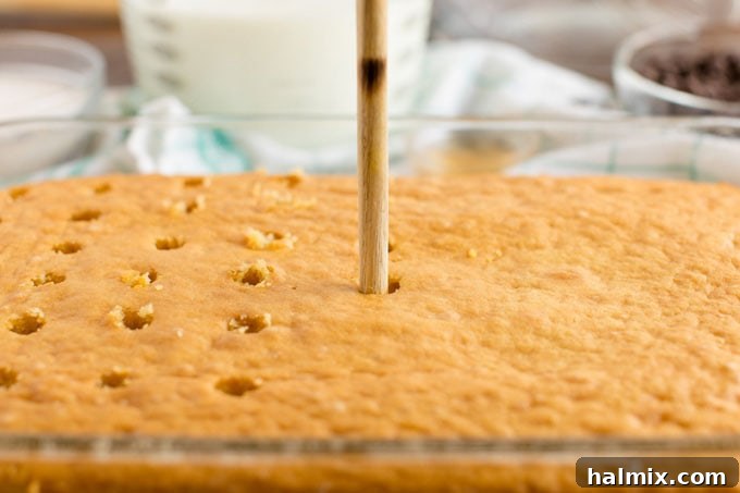 poking holes in a cake with a wooden spoon