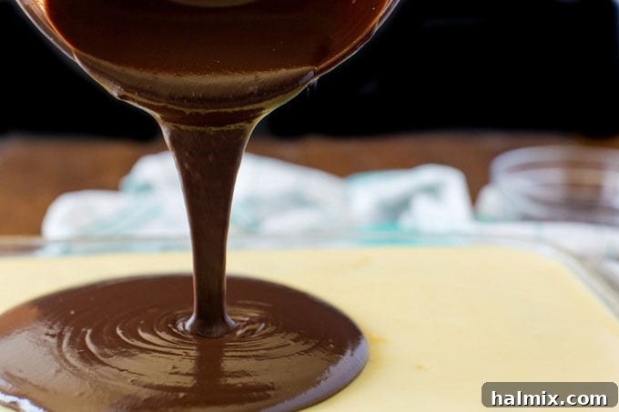 pouring chocolate over pudding layer on cake