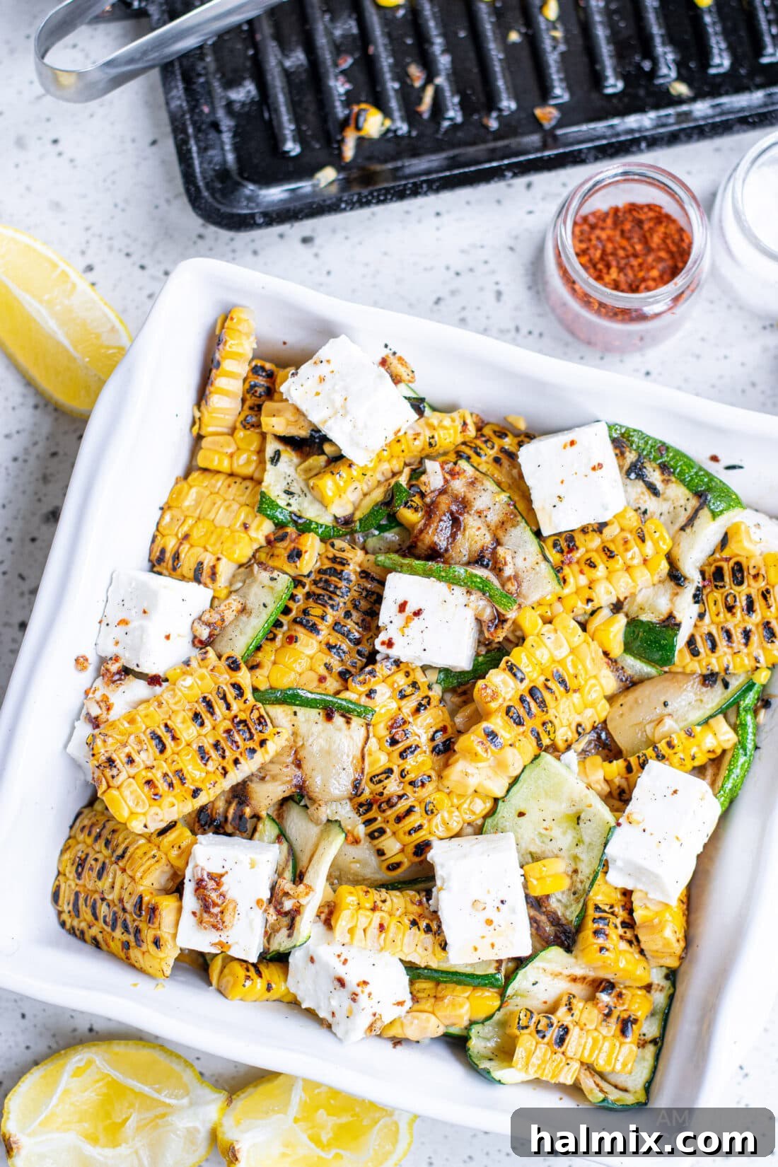 Grilled Corn & Zucchini Salad in a bowl, showcasing vibrant summer vegetables and crumbled feta