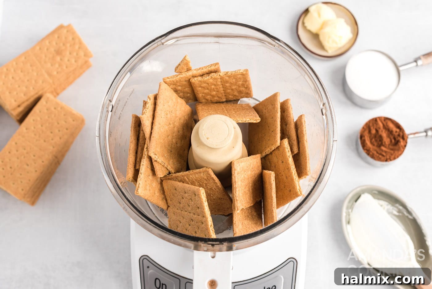 Graham crackers being pulsed into fine crumbs in a food processor, ready for the eclair cake topping.