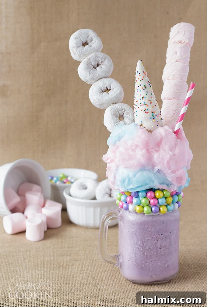 A single purple unicorn freakshake, lavishly garnished with mini donuts, fluffy cotton candy, and delicate marshmallows, evoking a dreamy, magical vibe.