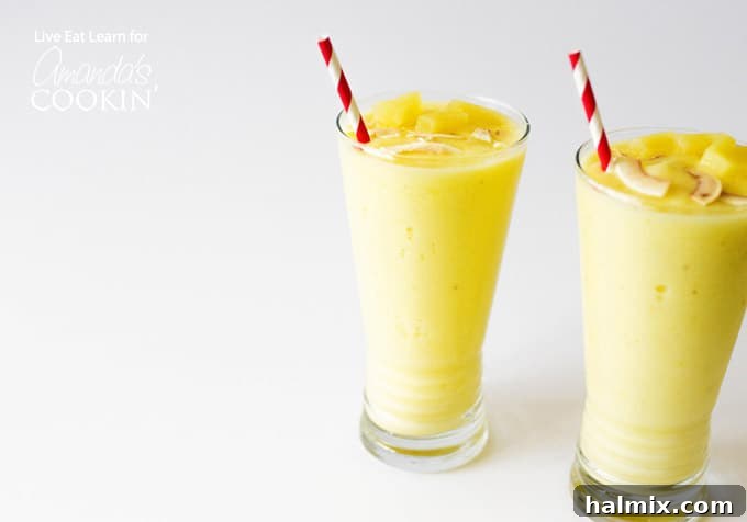 Close-up of a Pina Colada Smoothie in a glass with a straw and pineapple wedge