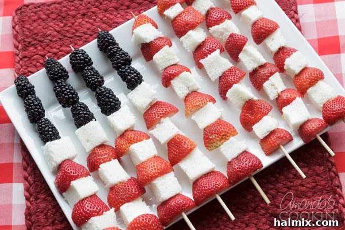 Serve these easy and delicious American Flag Kabobs at your Memorial Day or Fourth of July party for a refreshing dessert alternative! Close-up of Fourth of July American Flag Fruit Kabobs, showcasing vibrant red strawberries, white angel food cake, and dark blue blackberries