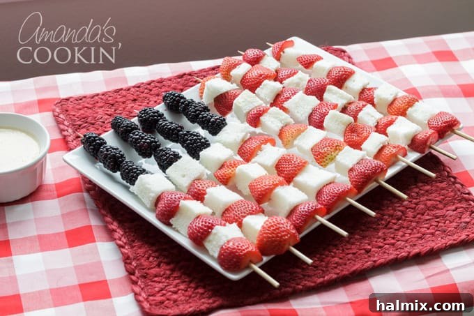These delightful fruit kabobs, shaped like the American flag, are a simple yet impressive dessert for any festive occasion. Beautifully arranged fruit kabobs mimicking the American flag, with strawberries, angel food cake, and blackberries on a white platter