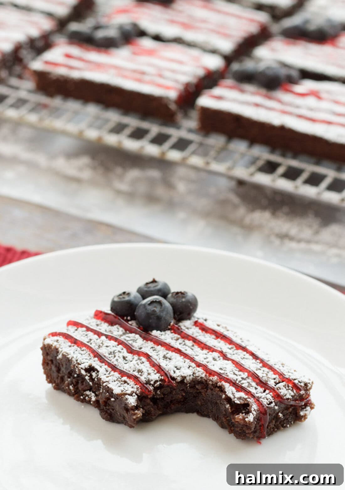 A single American Flag Brownie presented beautifully on a white plate with a corner bite taken out