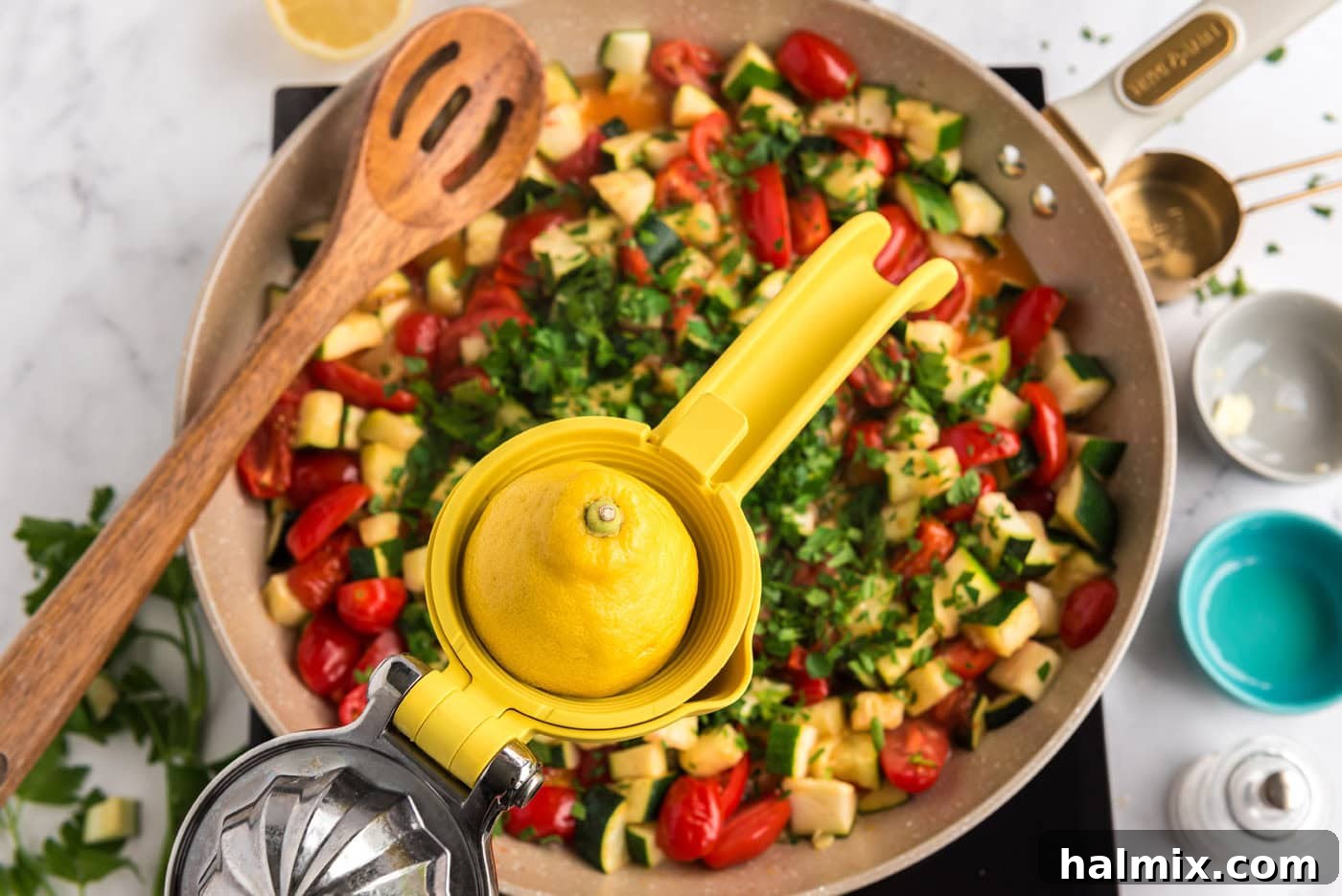 adding lemon juice to pan of zucchini and tomatoes with parsley