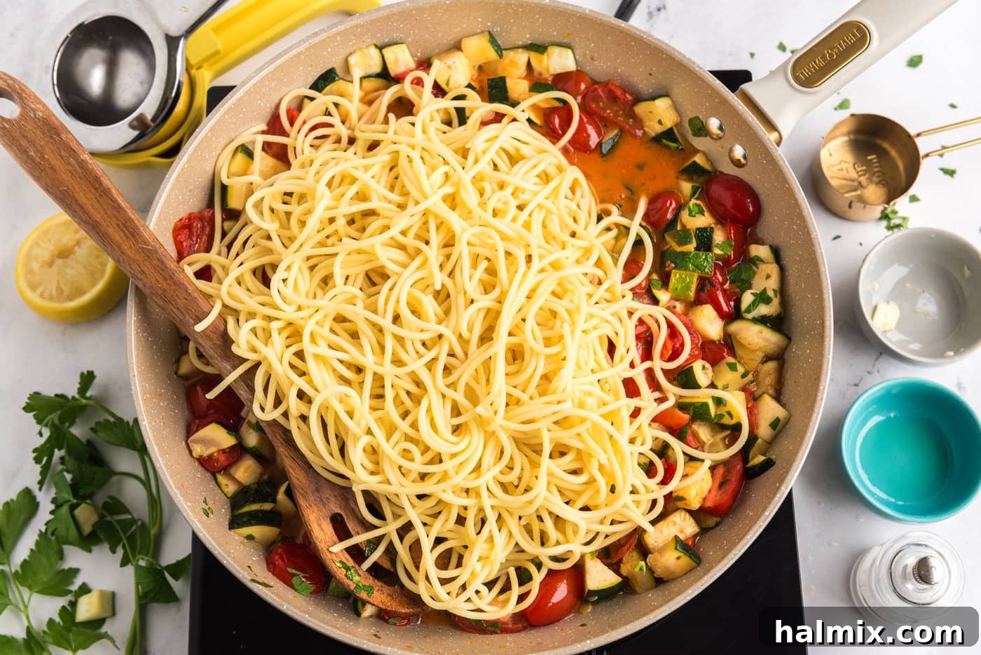 cooked pasta added to skillet with zucchini and tomatoes