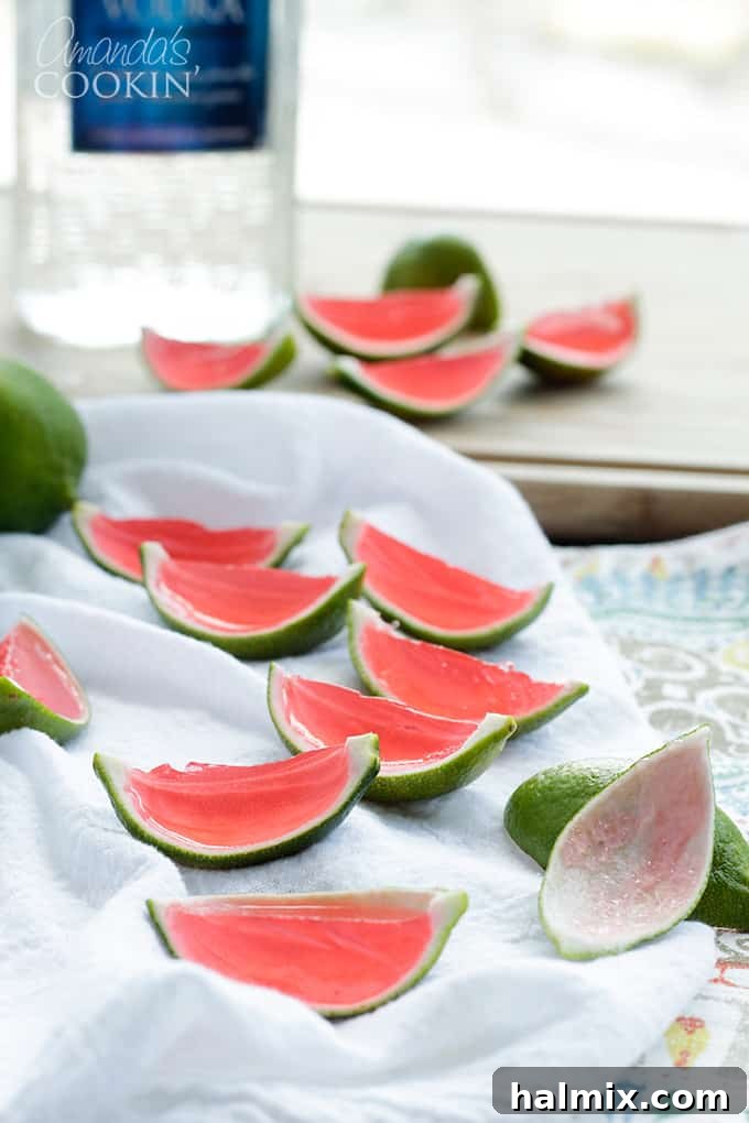 A close-up shot of adorable watermelon jello shots nestled in lime rinds, showcasing the bright colors and festive presentation for a party.
